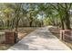 Long private driveway leading to a secluded property, framed by mature trees and landscaping at 2906 Pemberton Creek Dr, Seffner, FL 33584