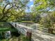 Scenic view of property with a long private bridge leading to a beautiful home nestled among trees at 2906 Pemberton Creek Dr, Seffner, FL 33584