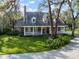 Charming brick home featuring a welcoming front porch, lush lawn, and mature trees at 2906 Pemberton Creek Dr, Seffner, FL 33584