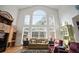 Sunlit living room with soaring windows, hardwood floors, and comfortable seating creating an airy space at 2906 Pemberton Creek Dr, Seffner, FL 33584