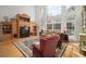 Bright living room featuring a tall built-in wall unit, large windows, and hardwood floors with an area rug at 2906 Pemberton Creek Dr, Seffner, FL 33584