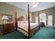 Floral main bedroom with four-poster bed, large window and decorative carpet at 2906 Pemberton Creek Dr, Seffner, FL 33584