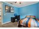 Bright bedroom with blue walls, ceiling fan, and desk offers a comfortable and inspiring space at 2915 W Bay View Ave, Tampa, FL 33611