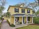 Charming yellow two-story home with a welcoming front porch and manicured landscaping at 2915 W Bay View Ave, Tampa, FL 33611