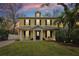 Inviting yellow two-story home with a covered front porch and well-manicured lawn at dusk at 2915 W Bay View Ave, Tampa, FL 33611