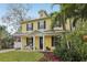 Charming yellow two-story home with a welcoming front porch, black shutters, and well-manicured lawn at 2915 W Bay View Ave, Tampa, FL 33611