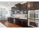 Stylish kitchen with dark cabinetry, mosaic backsplash, and stainless steel appliances and fixtures at 2915 W Bay View Ave, Tampa, FL 33611
