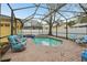 A screened-in pool area featuring a sparkling pool, spa, and comfortable seating at 2915 W Bay View Ave, Tampa, FL 33611