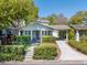 Quaint bungalow featuring a covered porch, carport, and lush green landscaping at 3007 W Angeles St, Tampa, FL 33629