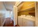 Bright laundry area featuring a washer and dryer, closet, and hardwood floors at 3007 W Angeles St, Tampa, FL 33629