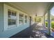 Inviting covered porch with dark wood flooring and white pillars, a perfect spot for relaxing at 3007 W Angeles St, Tampa, FL 33629