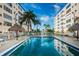 Sparkling community pool with tiki umbrellas, lounge chairs, and building views on a sunny day at 3010 59Th S St # 314, Gulfport, FL 33707