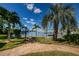 Beautiful waterfront view featuring a well-maintained path, palm trees, and benches under a sunny blue sky at 3010 59Th S St # 314, Gulfport, FL 33707