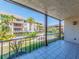 Balcony overlooking lush landscaping, a pool, and condominium buildings with palm trees on a sunny day at 3021 Countryside Blvd # 23A, Clearwater, FL 33761