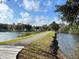 Scenic waterfront walking path beside a tranquil lake, providing a serene and inviting outdoor space at 3207 Sunwatch Dr, Wesley Chapel, FL 33544