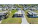 Aerial view of charming home with a covered carport, surrounded by lush green lawns and neighborhood at 37246 Eileen Ave, Zephyrhills, FL 33542