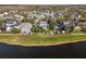 Aerial view of a lakeside neighborhood featuring a green lawn and mature landscaping at 3749 Zachary St, New Port Richey, FL 34655