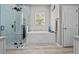 Bright bathroom featuring walk-in shower with a soaking tub and blue tiled walls at 3749 Zachary St, New Port Richey, FL 34655
