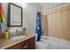 Well-lit bathroom featuring a granite vanity, shower-tub combo and essential bathroom fixtures with neutral color scheme at 3749 Zachary St, New Port Richey, FL 34655