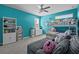 Bright bedroom with blue walls featuring a bunkbed, a plush gray couch, and carpeted flooring at 3749 Zachary St, New Port Richey, FL 34655