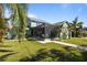 Charming home featuring a well-maintained lawn, palm trees, and a screened-in lanai for comfortable outdoor living at 3749 Zachary St, New Port Richey, FL 34655