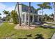 Two story house with a charming front porch, green lawn, and tropical landscaping at 3749 Zachary St, New Port Richey, FL 34655