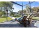 Enjoy the outdoor sun with comfortable chaise loungers overlooking the water in a screened-in lanai at 3749 Zachary St, New Port Richey, FL 34655