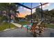 Relax outdoors under the sunset in the lanai in comfortable chaise loungers overlooking the water at 3749 Zachary St, New Port Richey, FL 34655