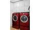 Laundry room with red washer and dryer and ample cabinet space at 449 S 12Th St # 1705, Tampa, FL 33602