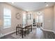 Cozy dining room with a glass table, modern chairs, tile floor, and a decorative clock on the wall at 4575 Tivoli Dr, Wesley Chapel, FL 33543