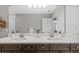 Bathroom featuring double sink vanity with white countertop, dark wood cabinets and large mirror at 4670 Emprise Way, Land O Lakes, FL 34638