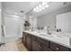 A pristine bathroom offers double sinks with white countertops and a well-lit vanity mirror at 4670 Emprise Way, Land O Lakes, FL 34638