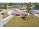 Aerial view of a single-story home with mature palm tree and attached garage in a quiet neighborhood at 4733 Bonton Dr, Holiday, FL 34690