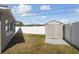 Backyard view of a house with a storage shed and white fence at 4733 Bonton Dr, Holiday, FL 34690