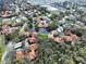 An aerial view of the community featuring well-maintained landscaping and tree-lined streets with red-tiled roofs at 513 Hammock Pine Blvd, Clearwater, FL 33761