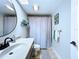 Bathroom featuring a stylish vanity, large mirror, and neutral tile flooring with a patterned rug at 513 Hammock Pine Blvd, Clearwater, FL 33761