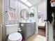 Bathroom featuring a patterned accent wall, modern vanity and door to main bedroom at 513 Hammock Pine Blvd, Clearwater, FL 33761