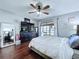 A bedroom featuring ceiling fan, wood floors, dresser with TV and patio access at 513 Hammock Pine Blvd, Clearwater, FL 33761
