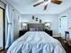 Comfortable bedroom features a ceiling fan, wood floors, and two large night stands at 513 Hammock Pine Blvd, Clearwater, FL 33761