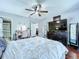 Bedroom features wood floors, TV on dresser, vanity, ceiling fan and access to bathroom at 513 Hammock Pine Blvd, Clearwater, FL 33761