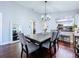 This dining room features wood floors, a chandelier, and views into the updated kitchen at 513 Hammock Pine Blvd, Clearwater, FL 33761