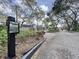 Gated community entrance with an intercom and lush landscaping at 513 Hammock Pine Blvd, Clearwater, FL 33761