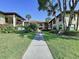 Beautiful condominium building with mature landscaping, sidewalks and palm trees at 513 Hammock Pine Blvd, Clearwater, FL 33761