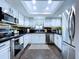 Well-lit kitchen showcases white cabinets, stainless steel appliances, and a decorative backsplash at 513 Hammock Pine Blvd, Clearwater, FL 33761