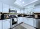 Well-equipped kitchen with stainless steel appliances, stylish backsplash and white cabinets at 513 Hammock Pine Blvd, Clearwater, FL 33761