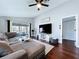 Open living room with wood floors, ceiling fan, and sliding glass doors to a patio at 513 Hammock Pine Blvd, Clearwater, FL 33761