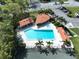 Aerial view of sparkling pool with lounge chairs, cabana, palm trees and parking at this community at 513 Hammock Pine Blvd, Clearwater, FL 33761