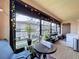 Sunroom with floor-to-ceiling windows, filled with plants and cozy furniture at 513 Hammock Pine Blvd, Clearwater, FL 33761
