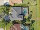 Aerial view of a gray roofed home with a screened in pool and well manicured landscaping at 5703 Tanagerside Rd, Lithia, FL 33547