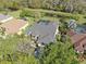 An aerial shot showcasing the home with a manicured landscaping, mature trees, and surrounding neighborhood at 5703 Tanagerside Rd, Lithia, FL 33547